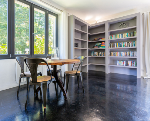 Corner of gite lounge showing bookcase and games table