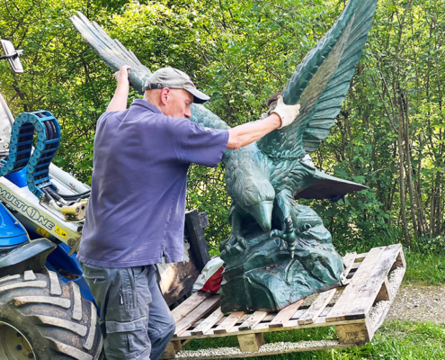 Carefully moving the statue with a digger