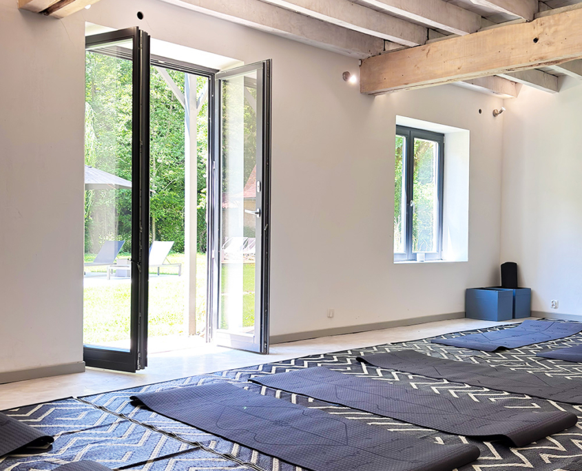 Dordogne yoga room with exposed beam ceilings and yoga mats on the floor